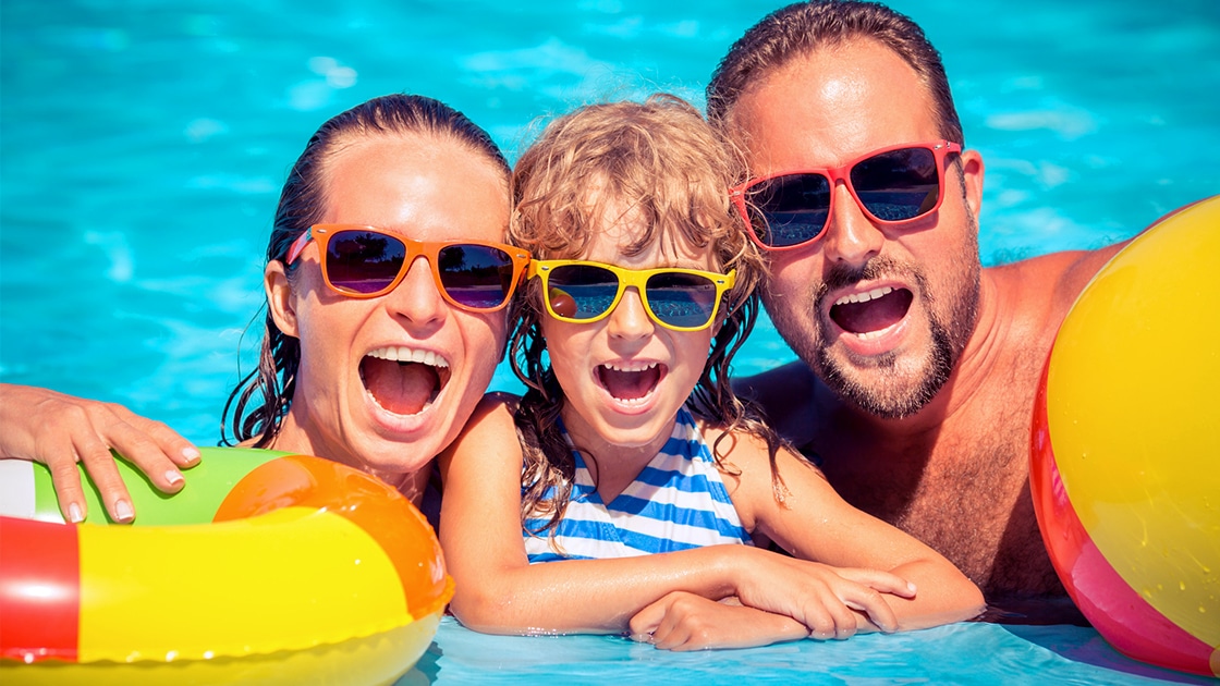 family smiling in pool